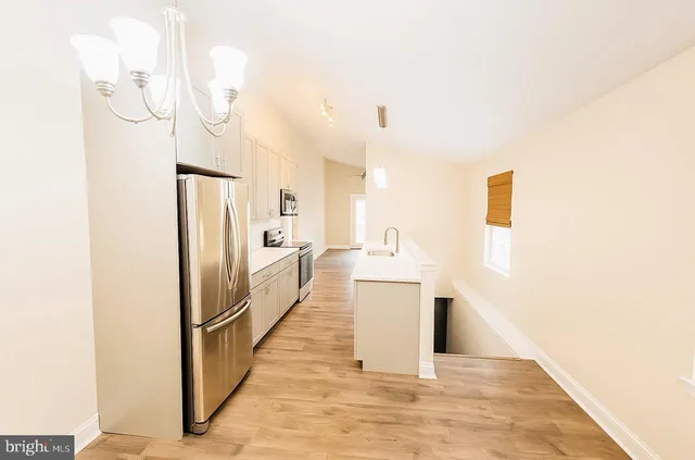 a kitchen with stainless steel appliances a refrigerator and a more cabinets