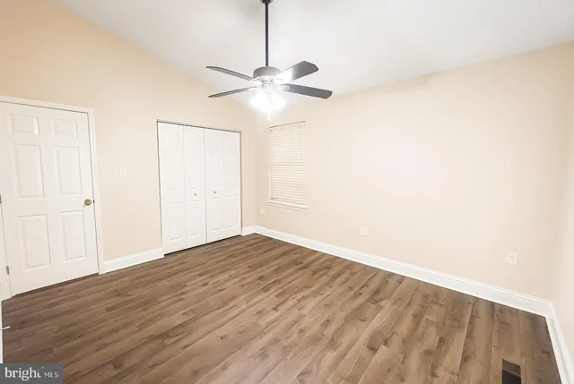 a view of empty room with wooden floor