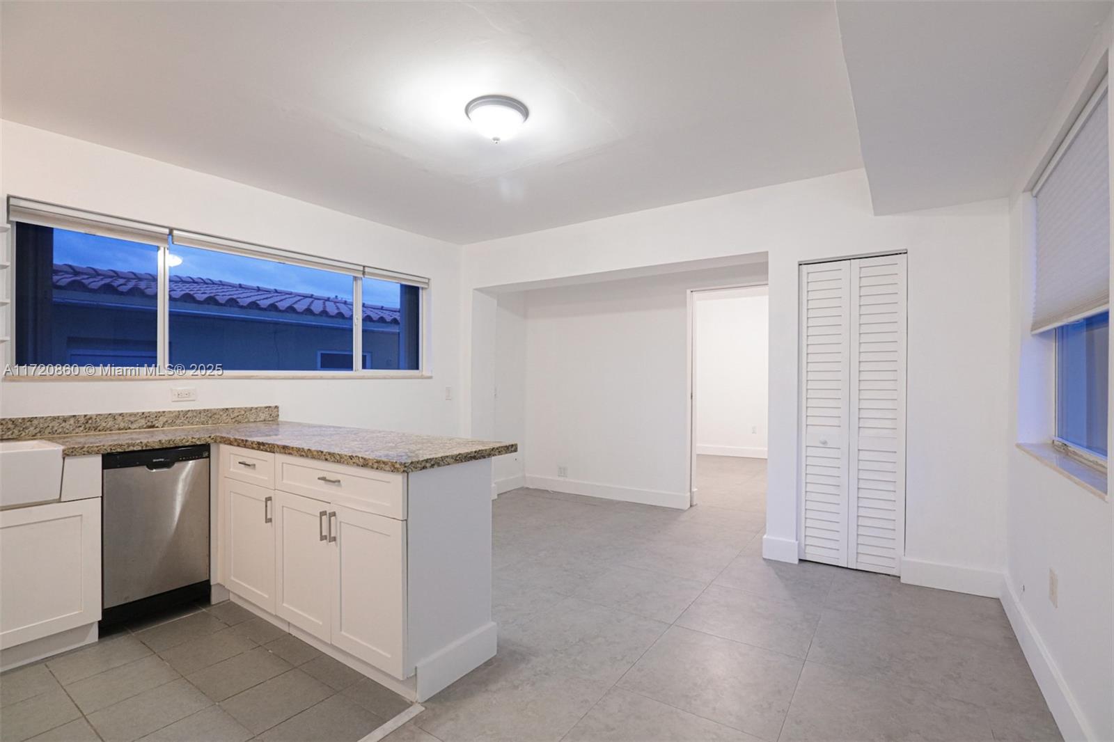 931 79th Terrace, Unit B Miami Beach, FL 33141 - Photo 2 of 9 a kitchen with granite countertop a sink and a stove