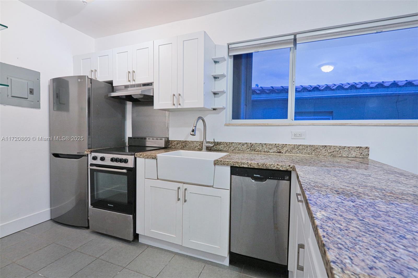 931 79th Terrace, Unit B Miami Beach, FL 33141 - Photo 3 of 9 a kitchen with a refrigerator sink and cabinets