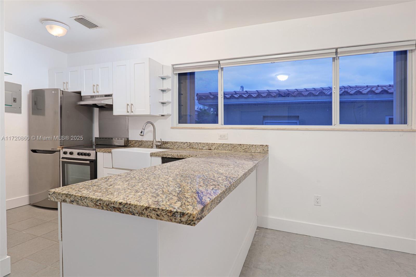 931 79th Terrace, Unit B Miami Beach, FL 33141 - Photo 4 of 9 a kitchen with stainless steel appliances granite countertop a sink stove and refrigerator