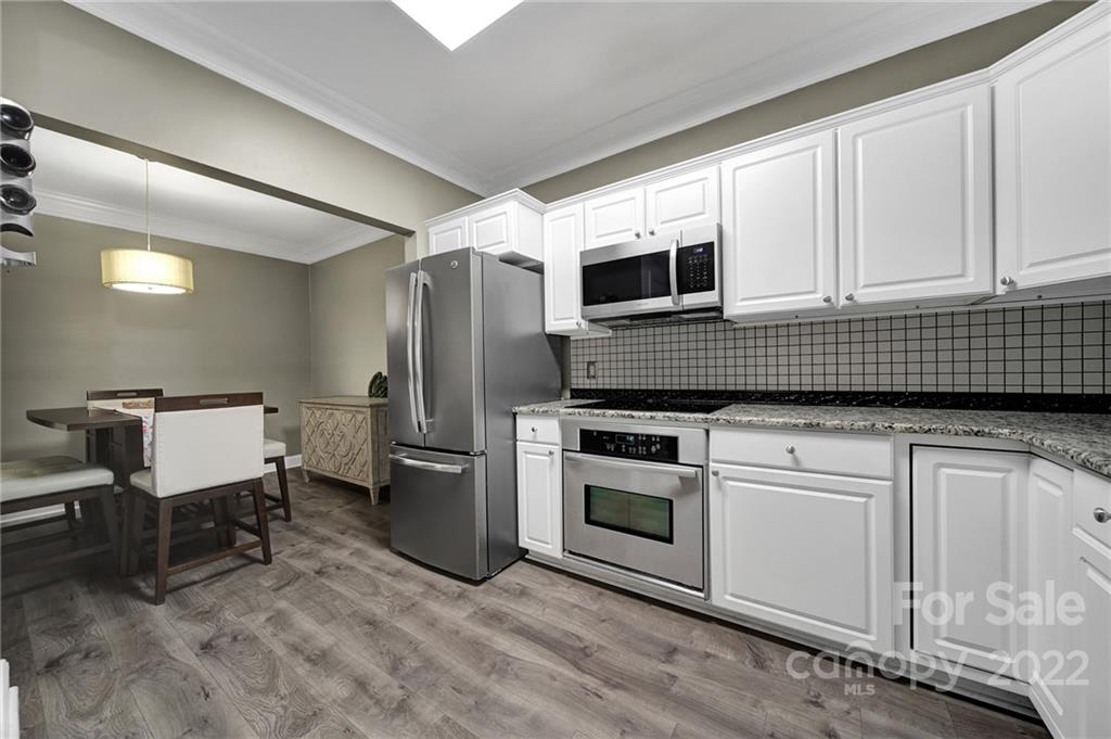 1012 Queens Road, Unit C Charlotte, NC 28207 - Photo 8 of 30 a kitchen with stainless steel appliances kitchen island granite countertop a stove a sink and a microwave