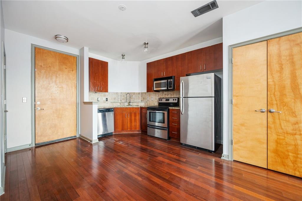 898 Oak Street Southwest, Unit 1418 Atlanta, GA 30310 - Photo 5 of 22 a kitchen with stainless steel appliances granite countertop a refrigerator a sink and a stove top oven