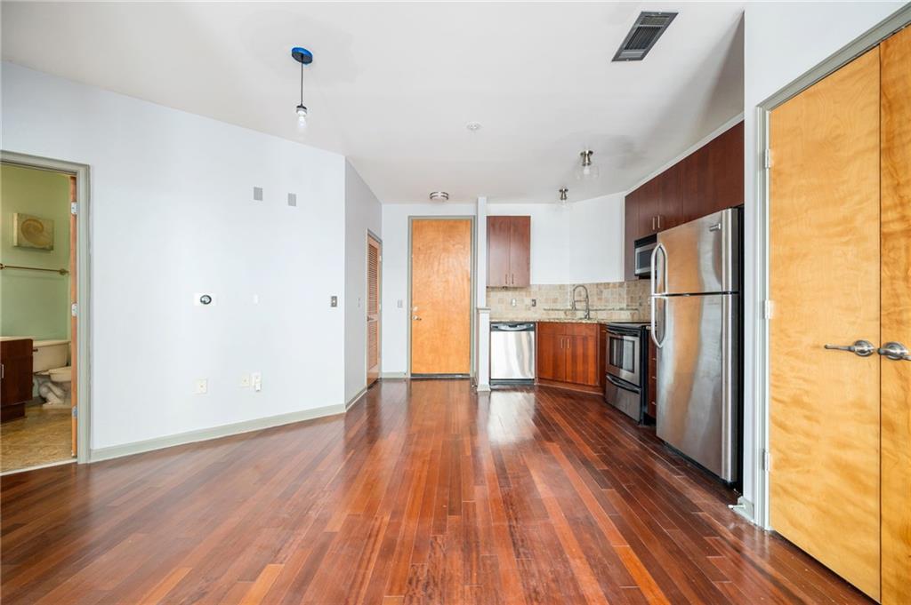 898 Oak Street Southwest, Unit 1418 Atlanta, GA 30310 - Photo 6 of 22 a kitchen with stainless steel appliances a refrigerator and wooden floor