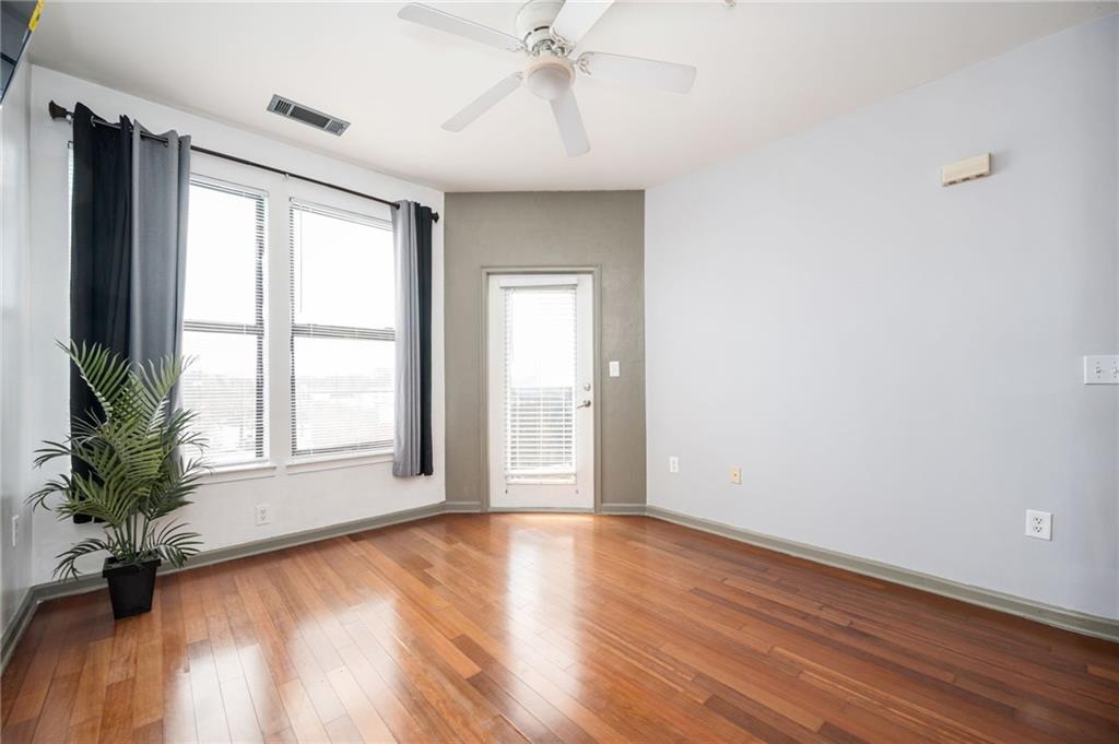 898 Oak Street Southwest, Unit 1418 Atlanta, GA 30310 - Photo 7 of 22 an empty room with wooden floor and windows