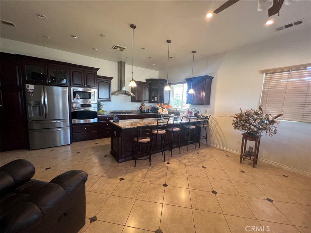 17305 Sage Avenue Riverside, CA 92504 - Photo 2 of 40 a kitchen with stainless steel appliances kitchen island granite countertop a refrigerator a sink a stove and a refrigerator