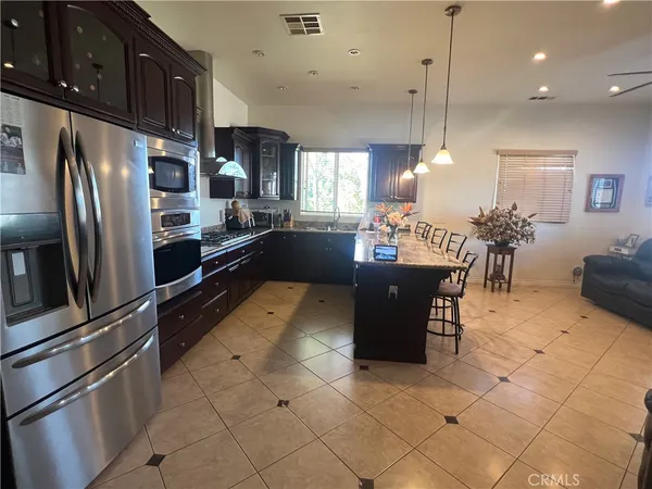 a kitchen with stainless steel appliances kitchen island granite countertop a refrigerator and a sink