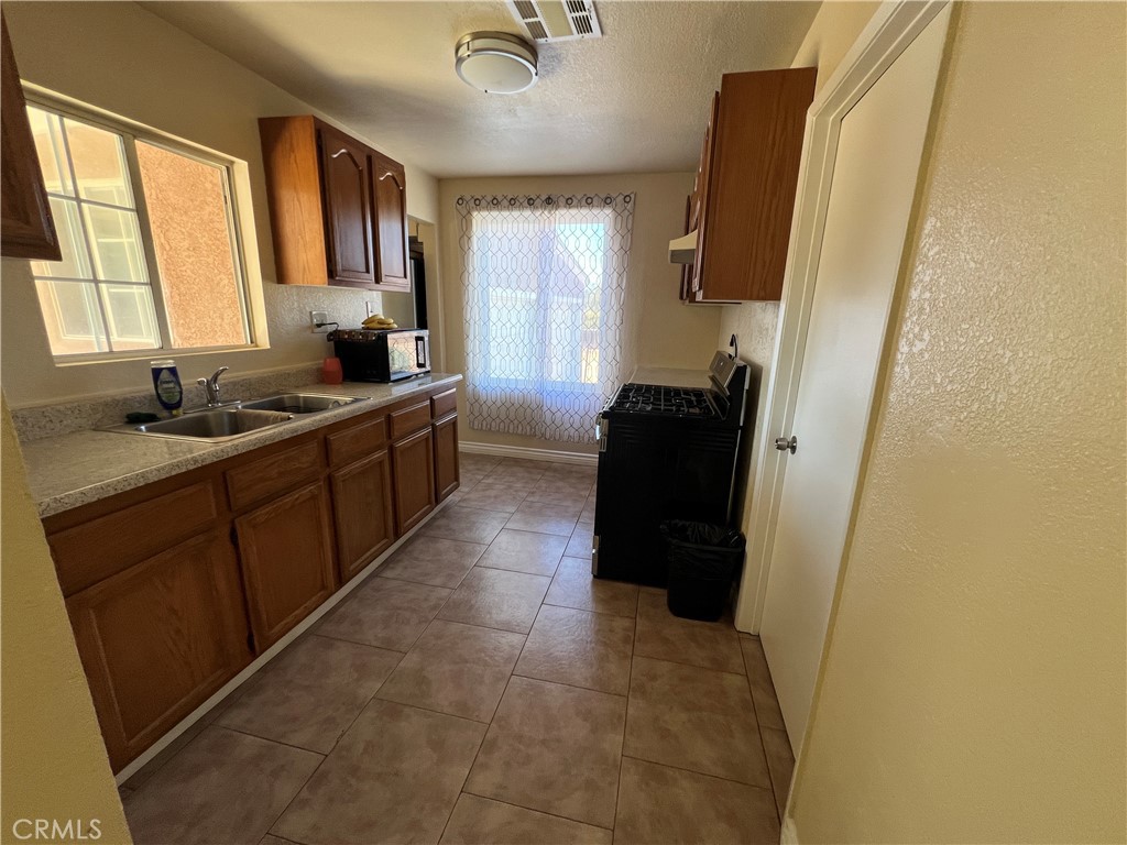17305 Sage Avenue Riverside, CA 92504 - Photo 37 of 40 a kitchen with a sink and a refrigerator