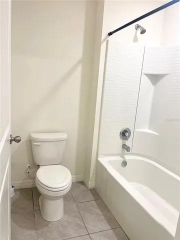 a white toilet sitting next to a bath tub