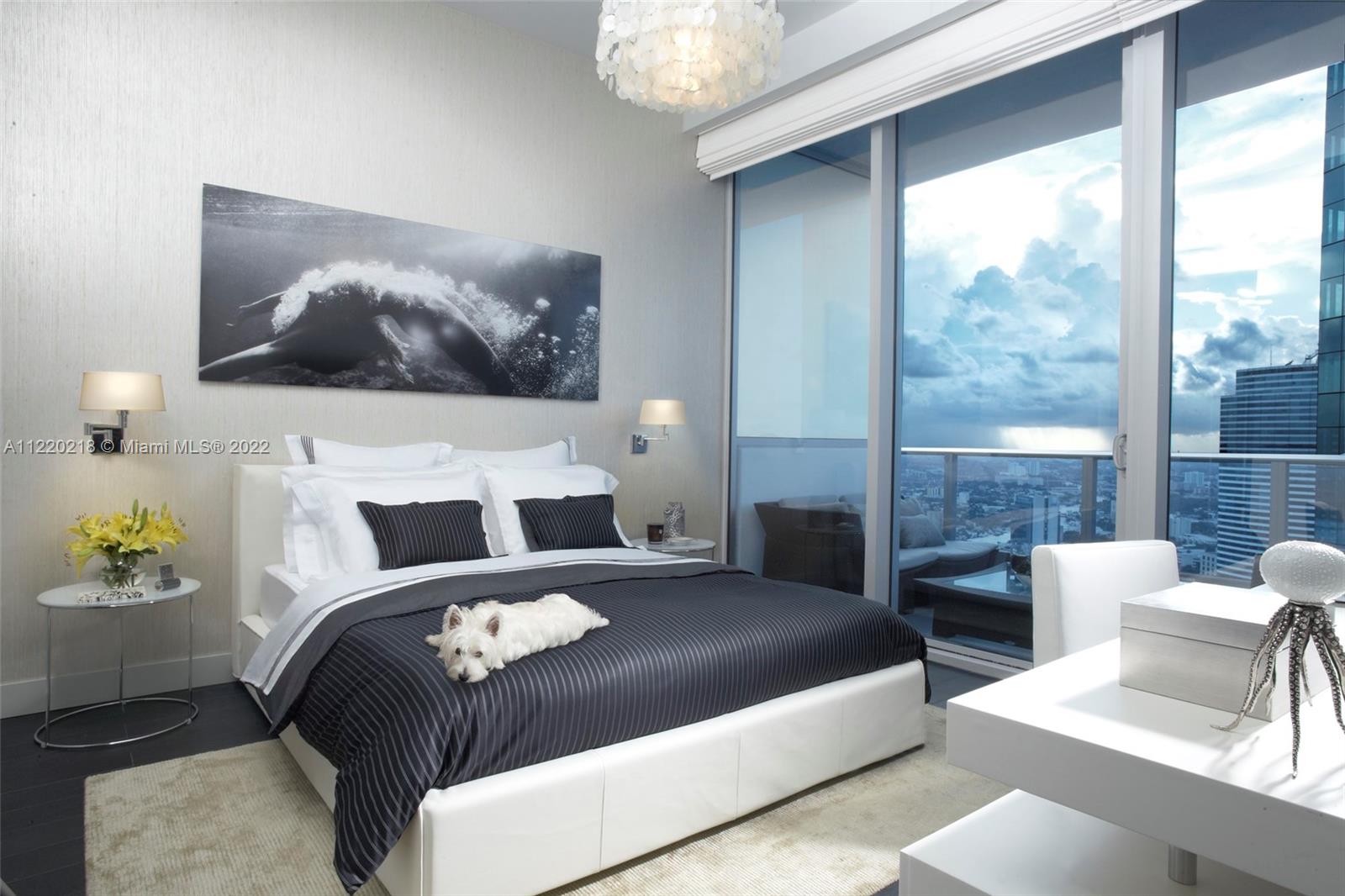 200 Biscayne Blvd Way, Unit 5211 Miami, FL 33131 - Photo 7 of 11 a bedroom with a large bed and a painting on the wall