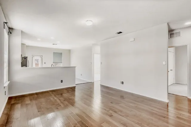 a view of a room with wooden floor and white walls