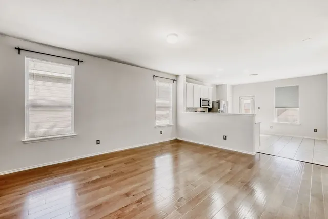 a view of a kitchen with wooden floor and a window