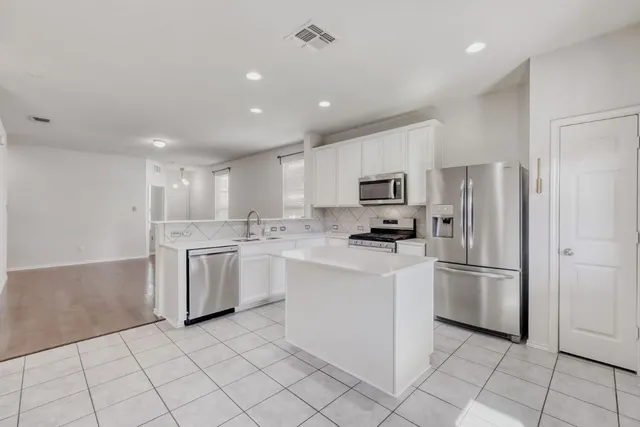 a kitchen with white cabinets stainless steel appliances and a sink