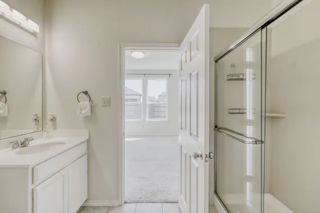 a bathroom with a double vanity sink mirror and shower