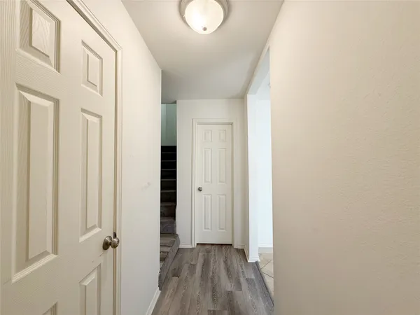 a view of a hallway with wooden floor and closet area