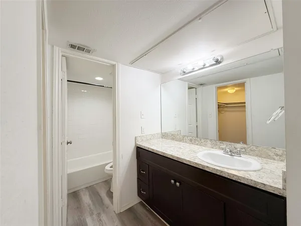 a bathroom with a granite countertop sink shower and a mirror