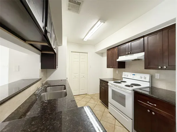 a kitchen with stainless steel appliances a stove a sink and a refrigerator