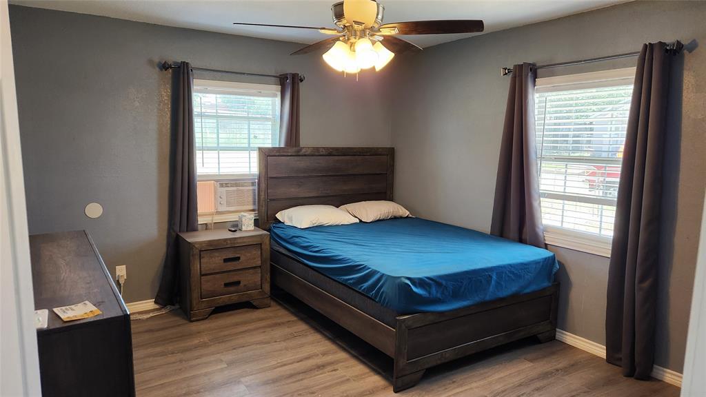 809 Bowie Street Sweetwater, TX 79556 - Photo 8 of 20 Bedroom with light wood finished floors, baseboards, a ceiling fan, and cooling unit