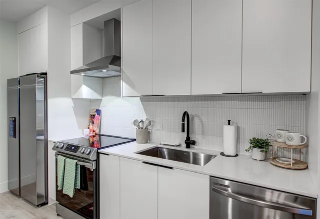 a kitchen with stainless steel appliances a sink and cabinets