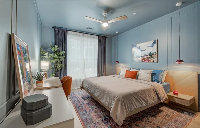 a bedroom with a bed a couch and a potted plant