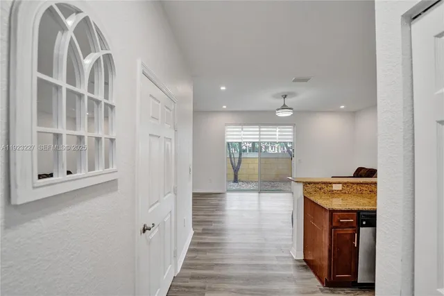 a hallway with wooden floor windows and entryway