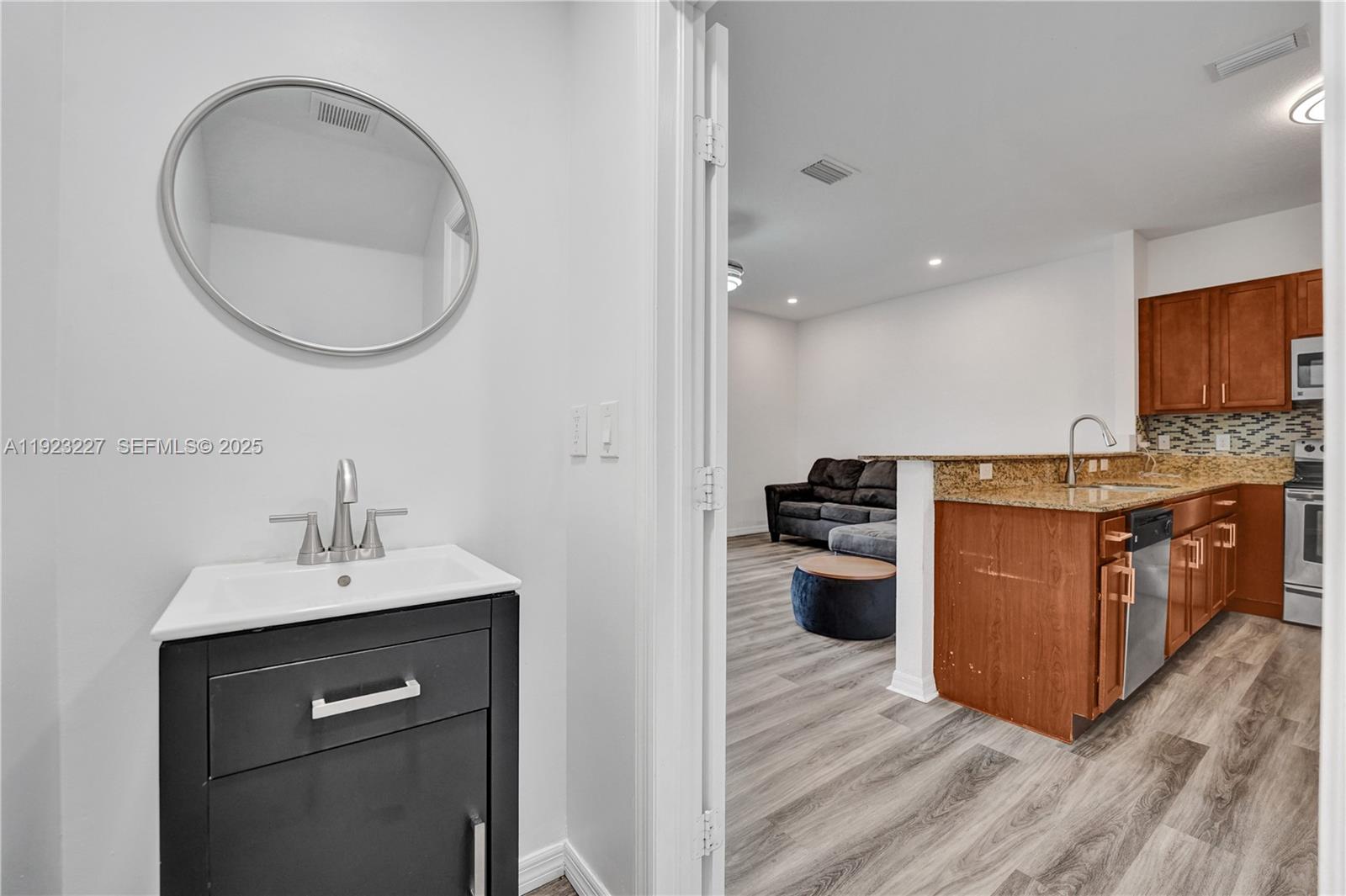 8993 Southwest 17th Court Miramar, FL 33025 - Photo 16 of 41 a kitchen with a sink cabinets and wooden floor