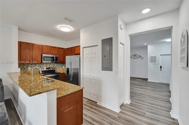 a kitchen with stainless steel appliances granite countertop a refrigerator and a stove top oven