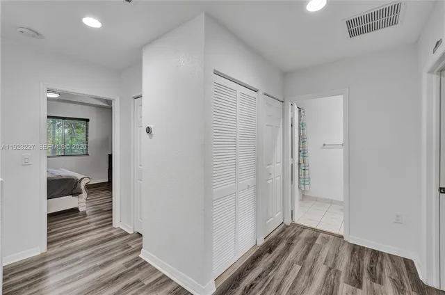 a view of a room with wooden floor and a bathroom
