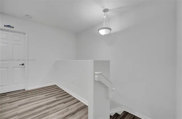a view of a room with wooden floor and fan