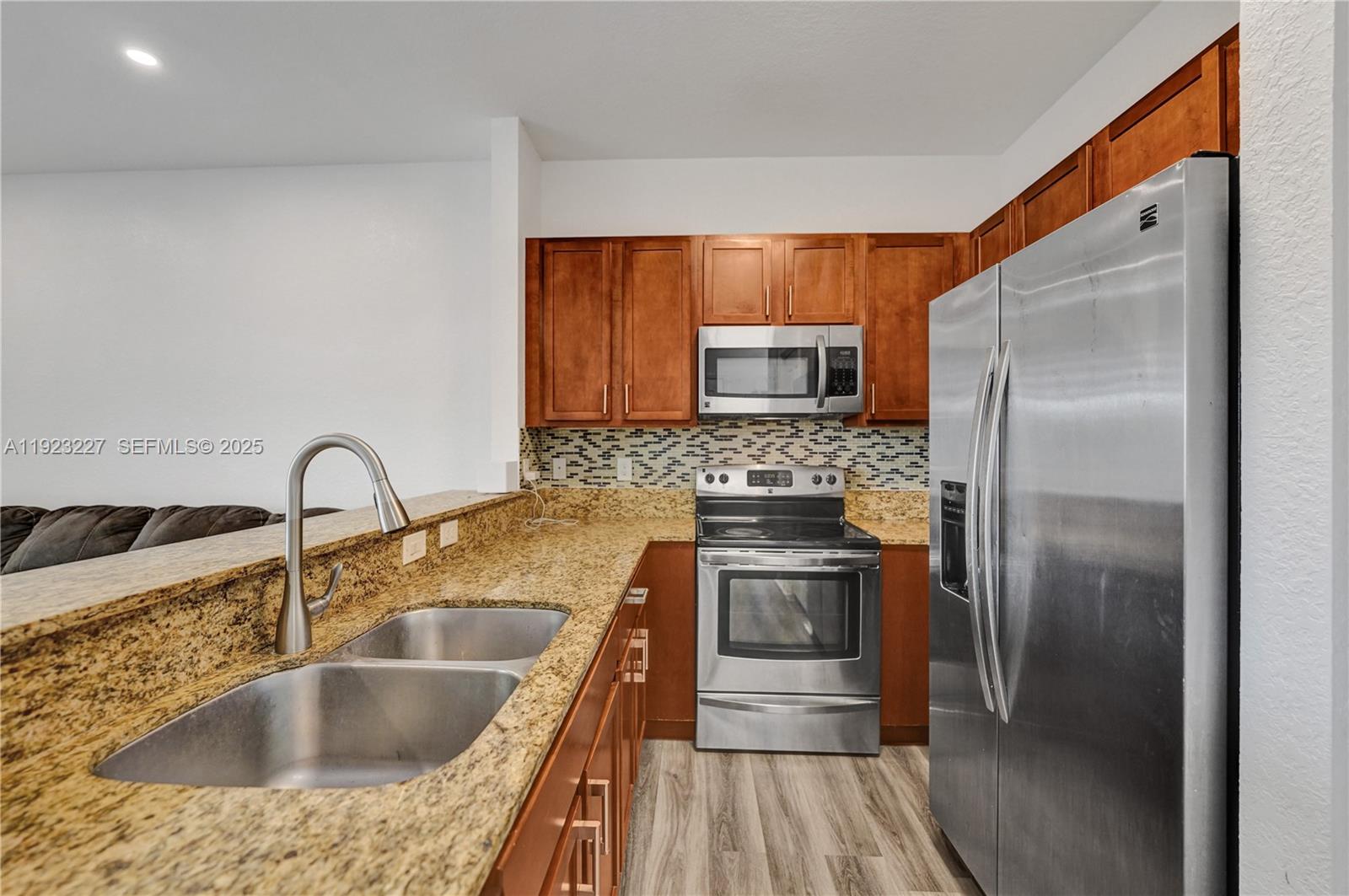 8993 Southwest 17th Court Miramar, FL 33025 - Photo 4 of 41 a kitchen with kitchen island granite countertop a sink stove and refrigerator