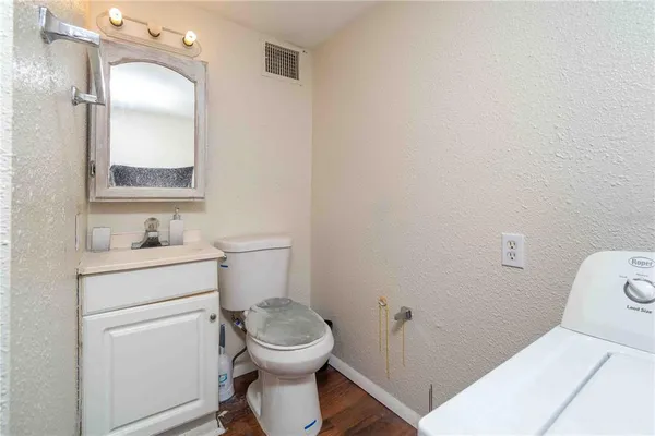 a bathroom with a toilet sink vanity and mirror