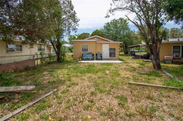 a front view of a house with a yard and large tree