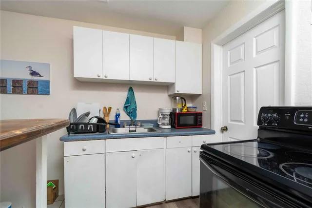 a kitchen with granite countertop white cabinets and black appliances