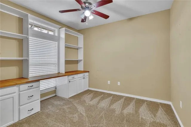 a spacious bedroom with a large bed a chandelier and windows