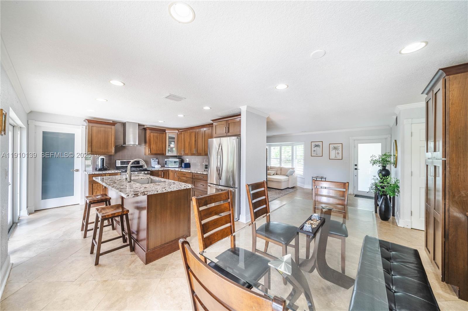 10320 Southwest 91st Street Miami, FL 33176 - Photo 13 of 30 a dining room with stainless steel appliances kitchen island granite countertop a table chairs and a refrigerator