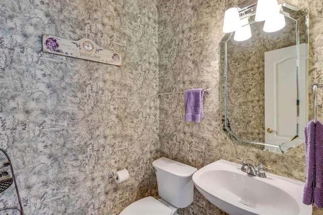 a bathroom with a toilet sink and mirror
