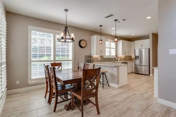 a view of a dining room and livingroom with furniture wooden floor a chandelier