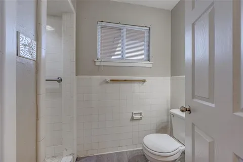 a white toilet sitting next to a bath tub
