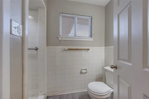 a white toilet sitting next to a bath tub
