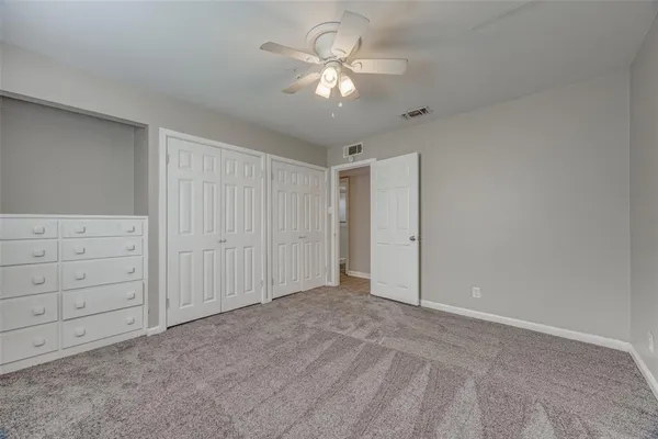 a view of an empty room with a ceiling fan