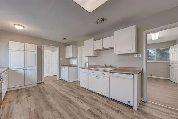 a kitchen with granite countertop a sink stove and cabinets