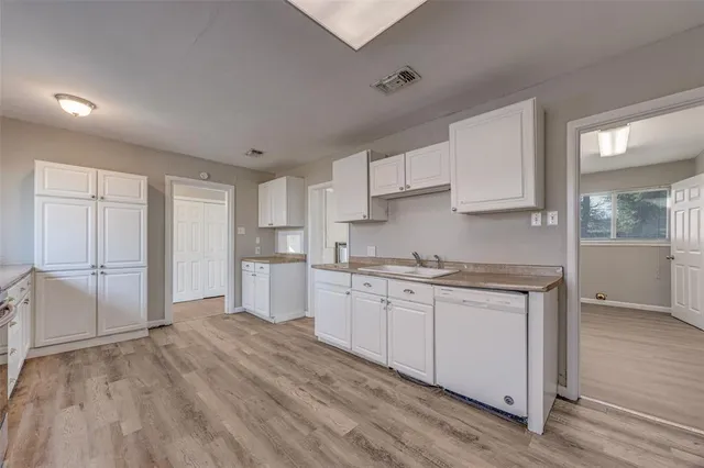 a kitchen with granite countertop a sink stove and cabinets