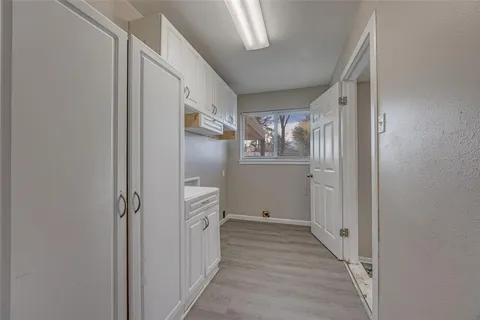 a view of a hallway with wooden floor and closet