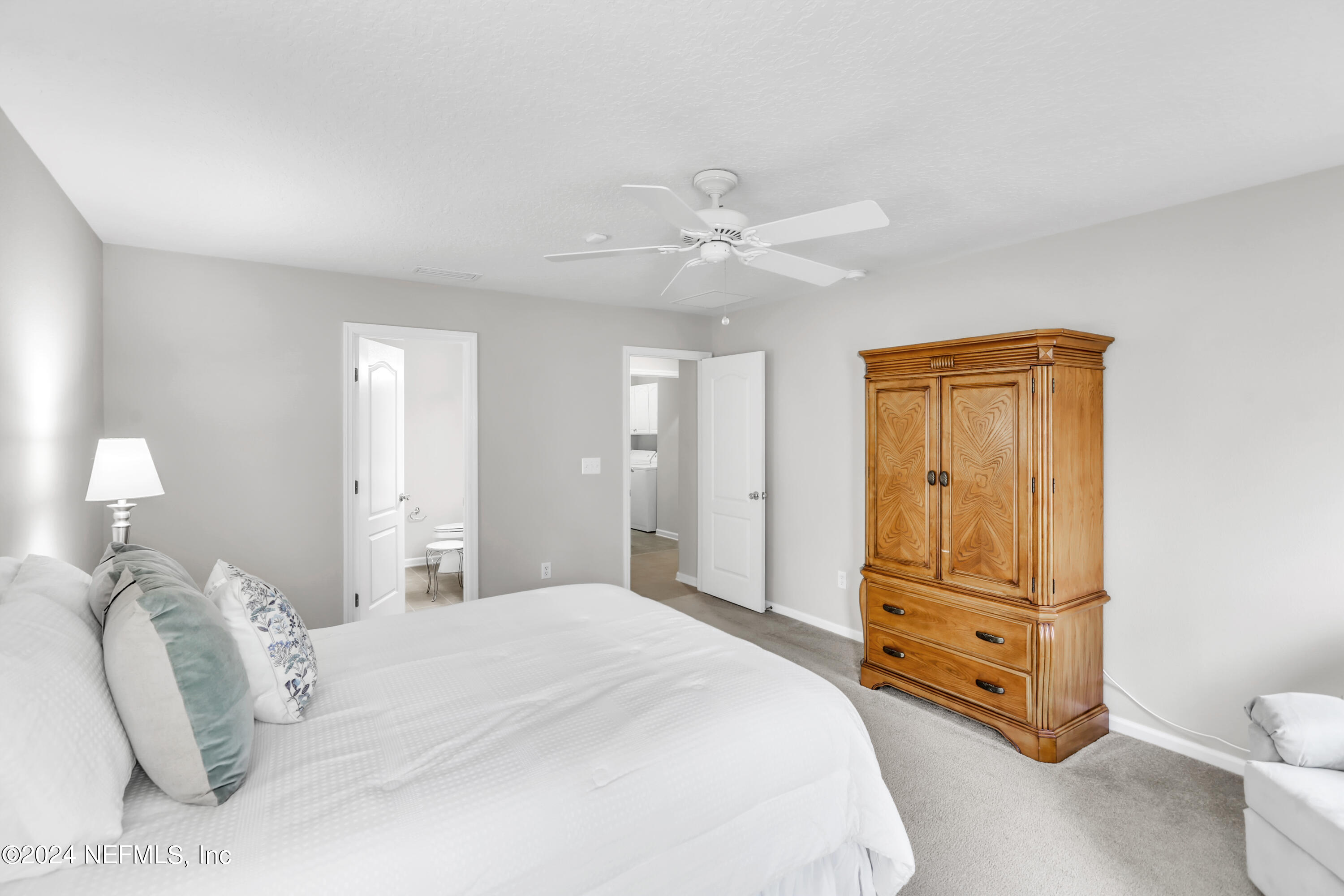 1184 Nochaway Drive St. Augustine, FL 32092 - Photo 18 of 39 a bedroom with a bed and a chandelier