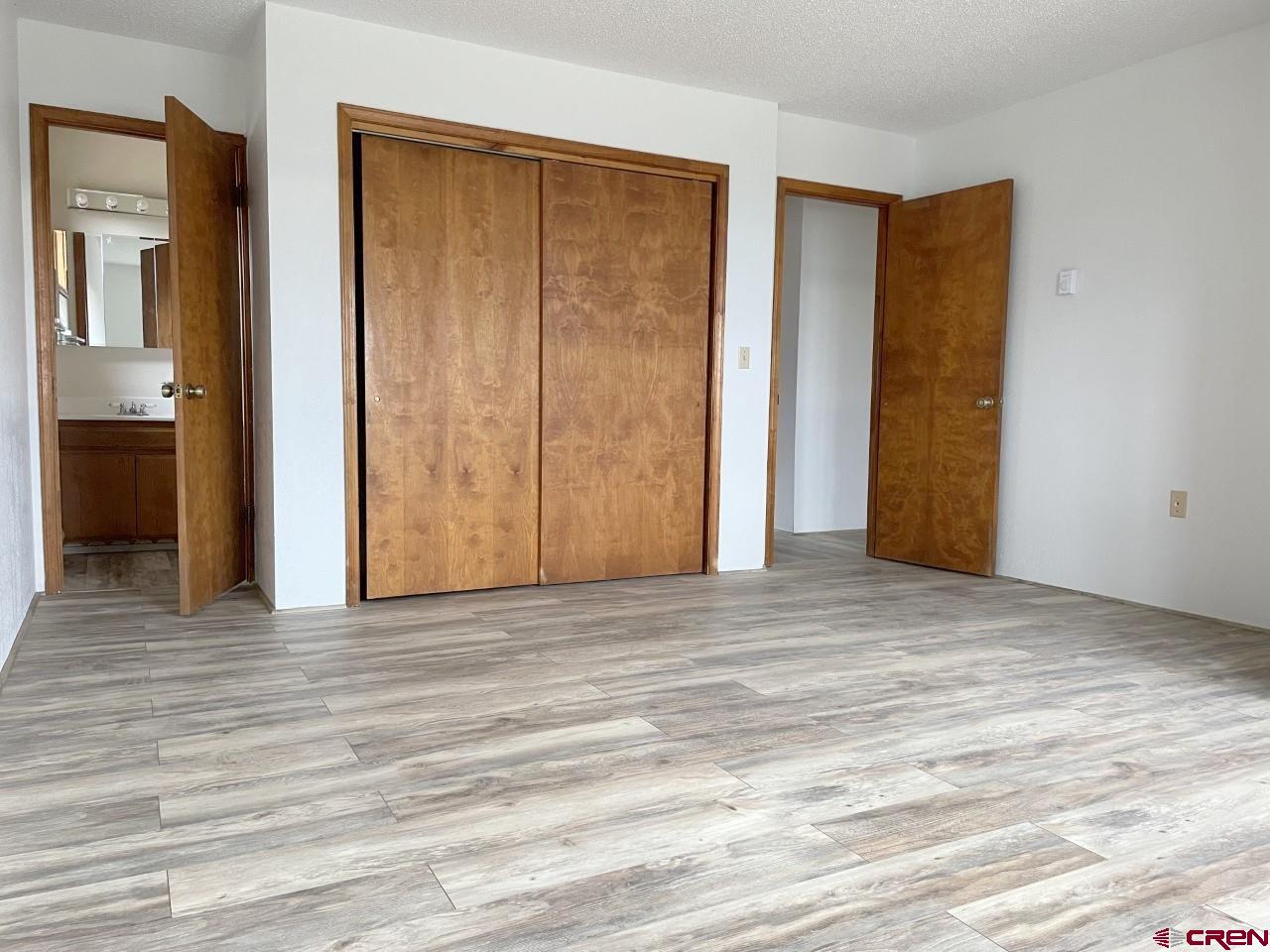 21566 Uintah Road Cedaredge, CO 81413 - Photo 17 of 33 a view of an empty room with wooden floor and a bathroom