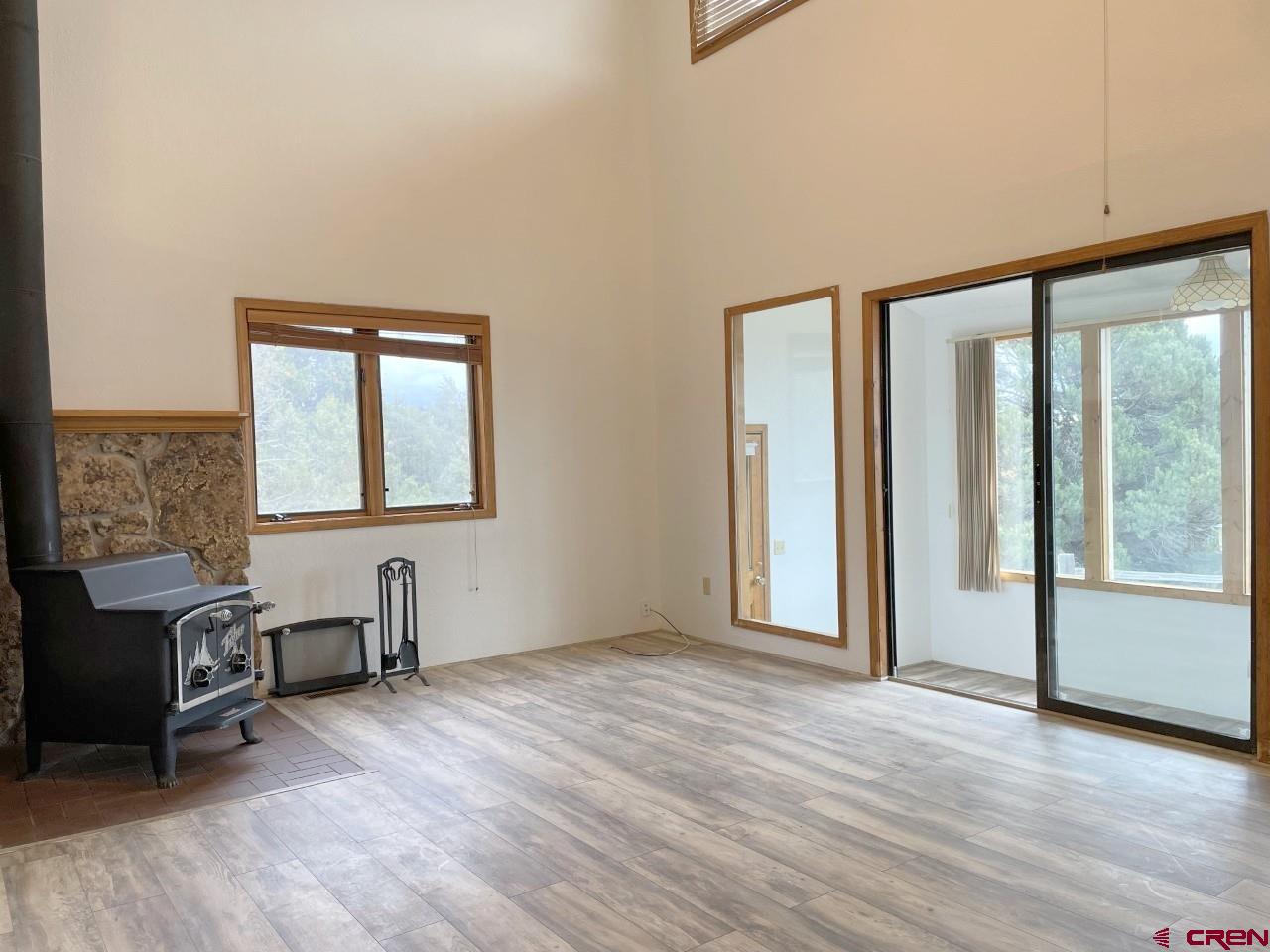 21566 Uintah Road Cedaredge, CO 81413 - Photo 5 of 33 an empty room with windows and wooden floor