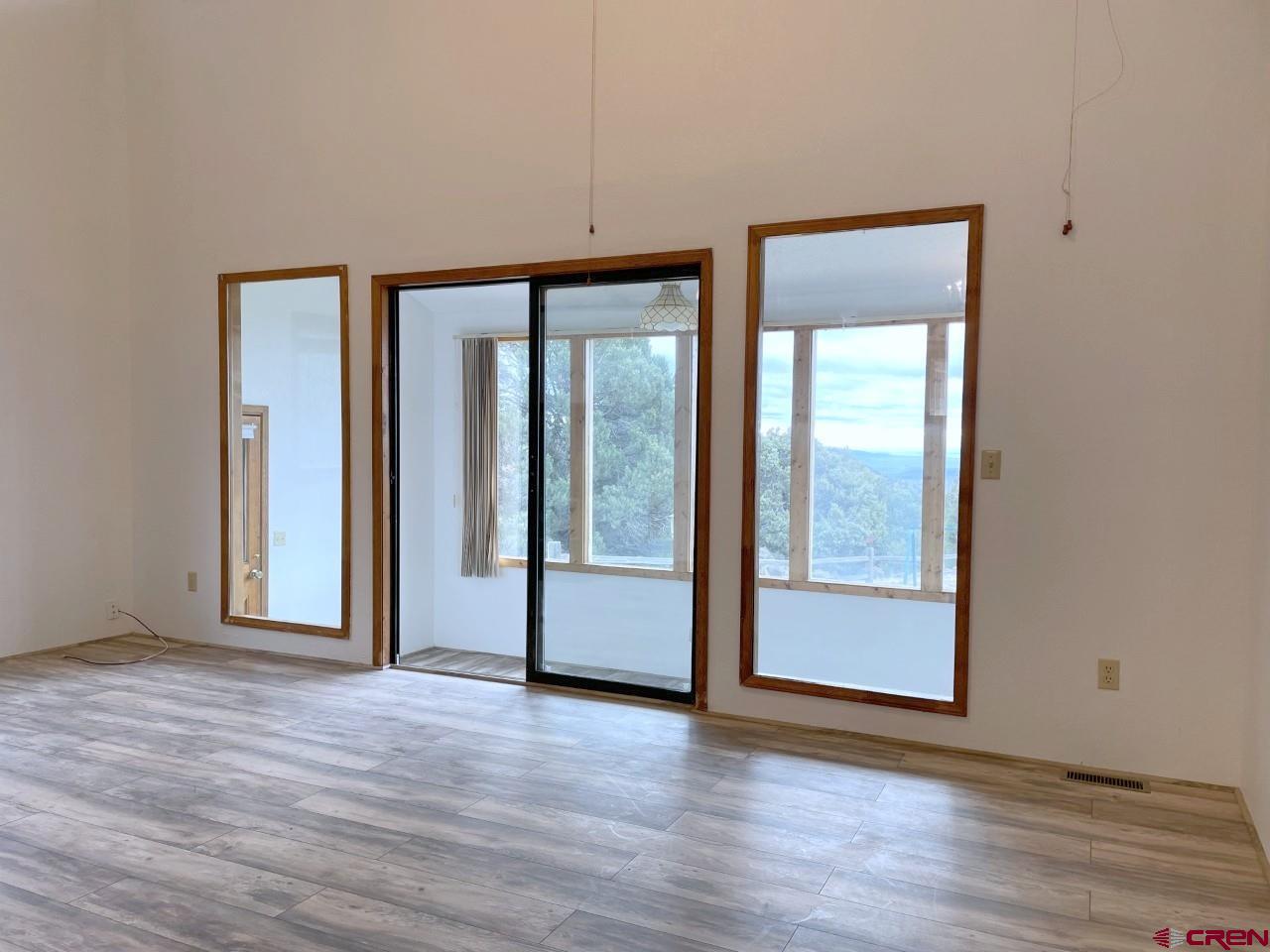 21566 Uintah Road Cedaredge, CO 81413 - Photo 6 of 33 an empty room with wooden floor and windows