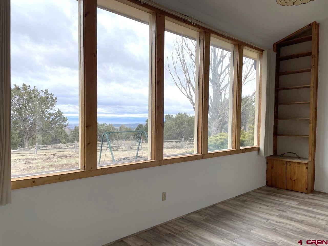 21566 Uintah Road Cedaredge, CO 81413 - Photo 8 of 33 a view of an empty room with wooden floor and a window