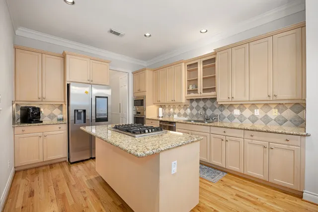 a kitchen with stainless steel appliances granite countertop a stove a sink dishwasher and a refrigerator