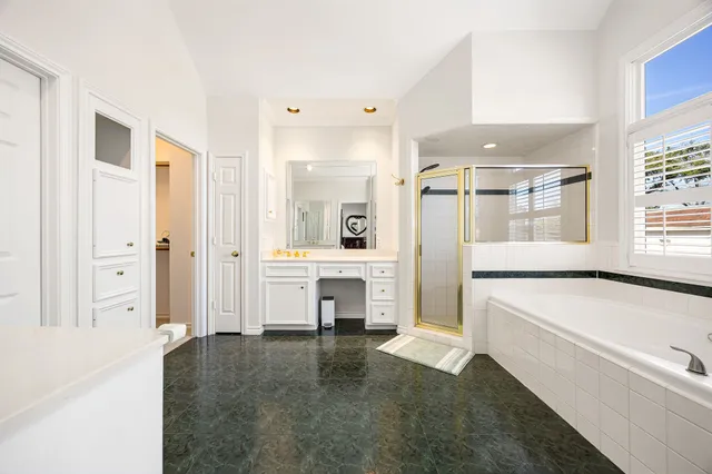 a large white kitchen with cabinets and a refrigerator